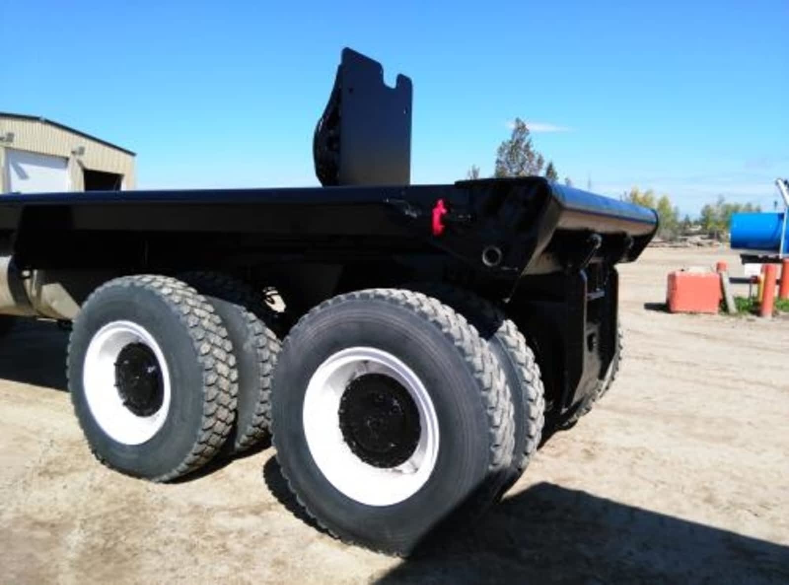 The rear axles of a red and black bedtruck